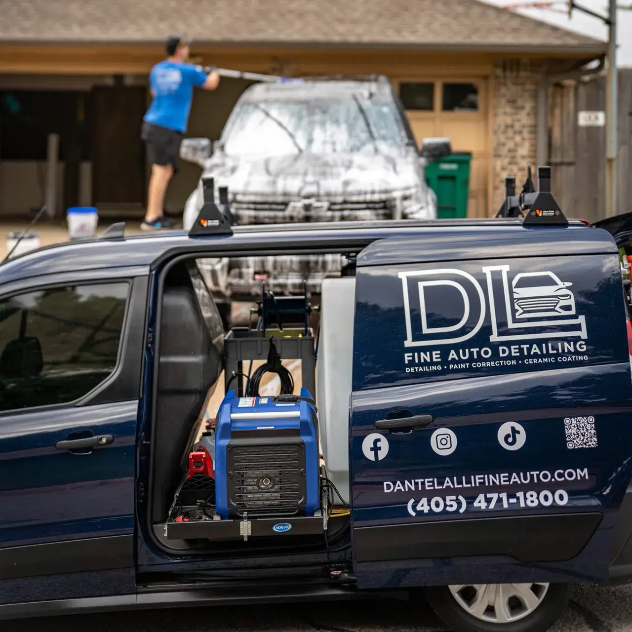 OKC Auto Care Experience Dante powerwashing vehicle behind DL Fine Auto van