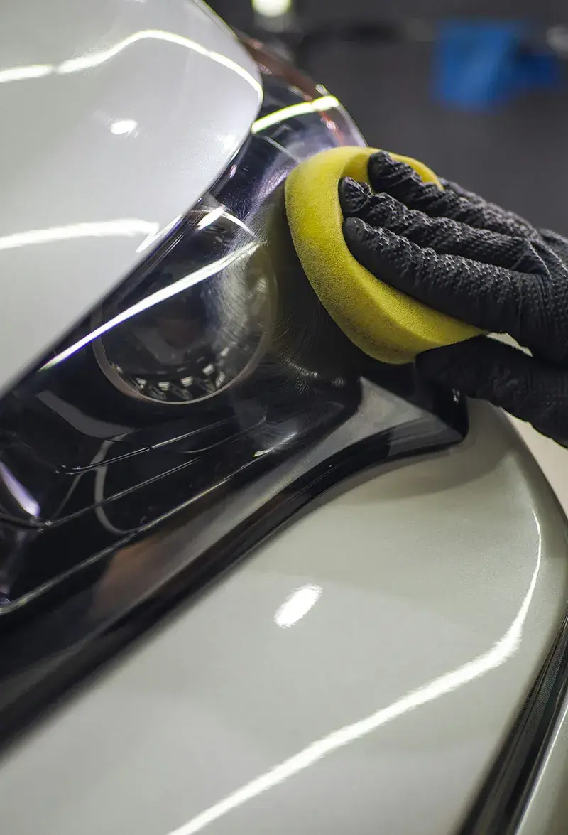 Hand-washing exterior of white vehicle