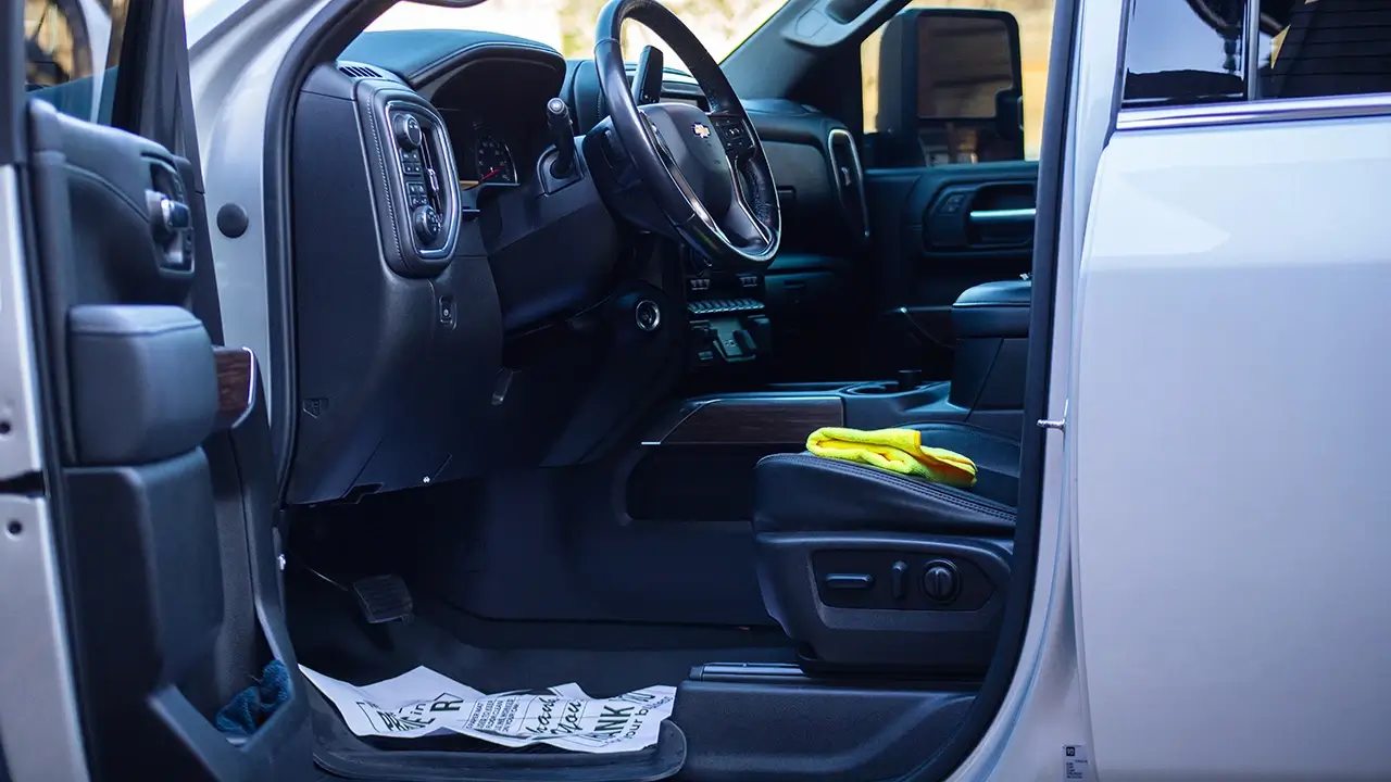 The inside driver seat of a freshly detailed white truck