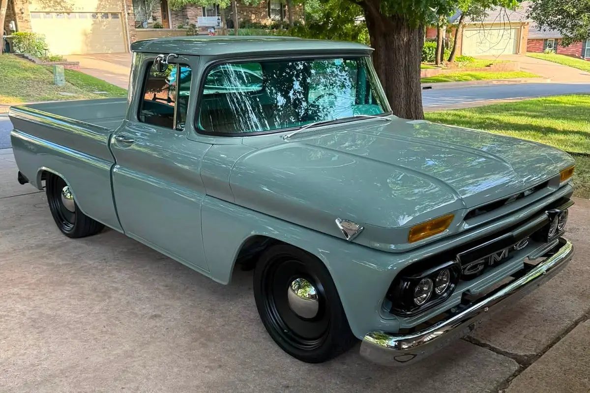 Restored vintage GMC pickup truck with a glossy light gray finish parked in a residential driveway.